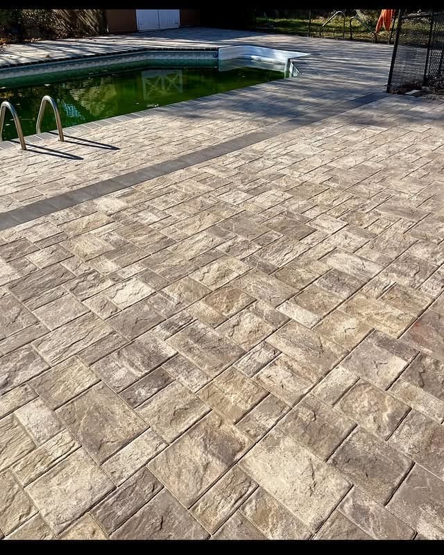 Ledgestone paver patio surrounding a pool, completed by Fernando Masonry